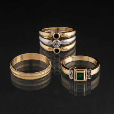 Conjunto de tres anillos en oro amarillo y blanco de 18 kt con brillantes, zafiro y esmeralda.