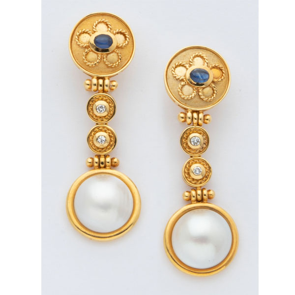 Pendientes largos en oro amarillo con decoración de flor, zafiro azul cabujón central, 2 diamantes talla brillante y perla japonesa.