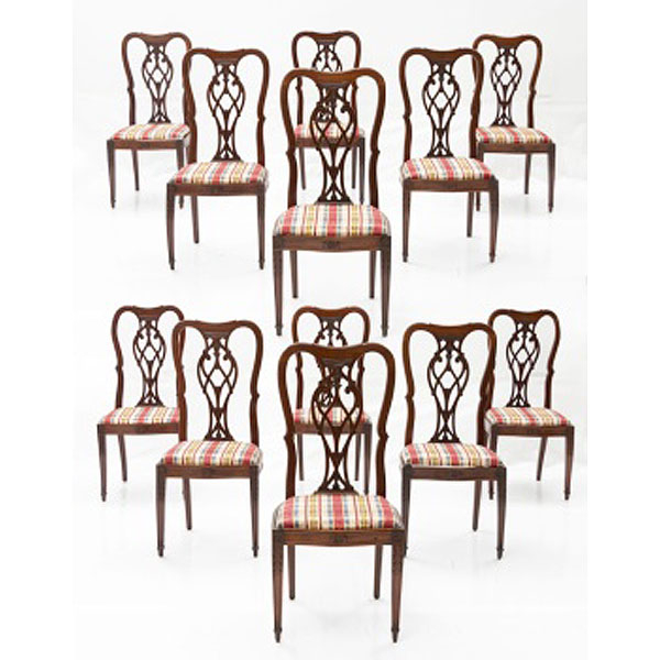 Conjunto de 12 sillas de comedor en madera de caoba tallada con decoración vegetal y asiento tapizado a cuadros. Estilo Victoriano.  Época: Pp. S. XX