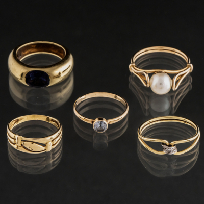 Conjunto de cinco anillos en oro amarillo de 18 kt con perla, zafiro y topacio.
