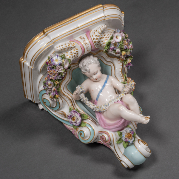 Mensula en porcelana esmaltada decorada con niño con guirnaldas. Siglos XIX-XX