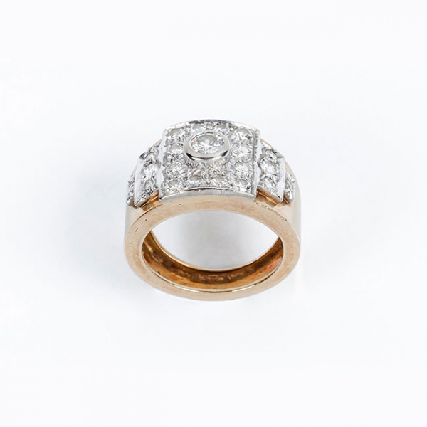 Sortija años 60-70, en sólida montura de oro rosa con un limpio y blanco diamante central, talla brillante, sobre motivo frontal en oro blanco, cuajado de brillantes en decoración cincelada.
