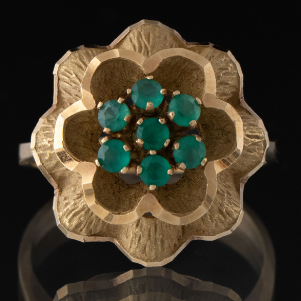 Elegante anillo en forma de flor en oro amarillo de 18 kt con esmeraldas.