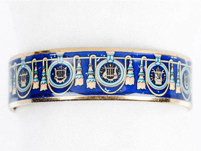 Brazalete esclavo de HERMÈS Paris (made in Austria), con cantos de oro y decoración esmaltada sobre fondo azul.