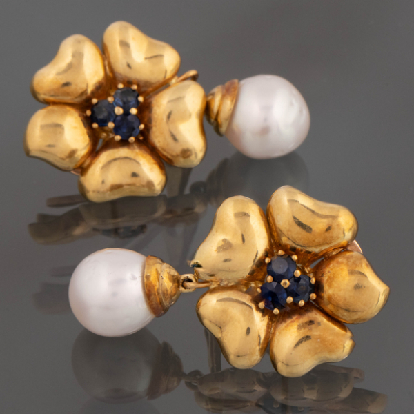 Pareja de pendientes en forma de flor en oro amarillo de 18kt con zafiros en el centro y perla cultivada.