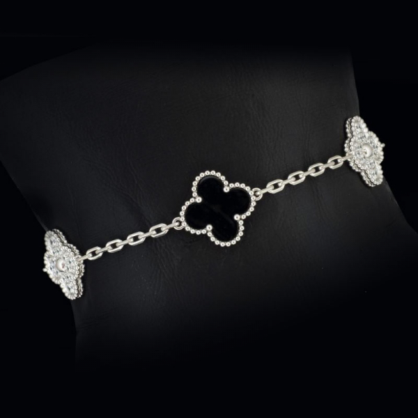 Pulsera de oro blanco de 18 K. marca VAN CLEEF&amp; ARPELS, con flores de onix y diamantes.