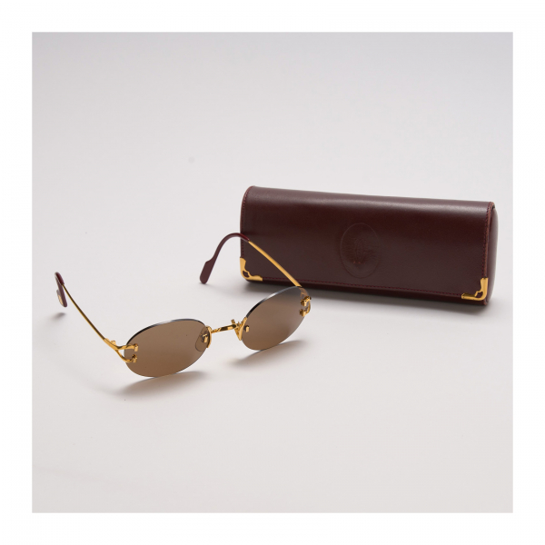 CARTIER. Gafas de sol modelo «Salisbury». Montura en metal dorado con patillas rematadas en resina burdeos logotipada. En muy buen estado.