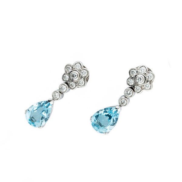 Elegantes pendientes largos en oro blanco 18 K con rosetón de limpios y blancos diamantes, talla brillante, en chatón y topacio azul 