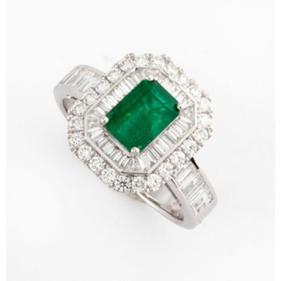 Sortija en oro blanco con esmeralda central, orla de diamantes talla baguette y en el brazo y orla de diamantes talla brillante