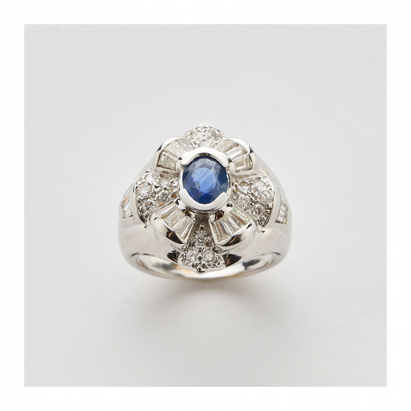 Sortija en oro blanco con zafiro azul talla oval y diamantes tallas brillante y trapecio.