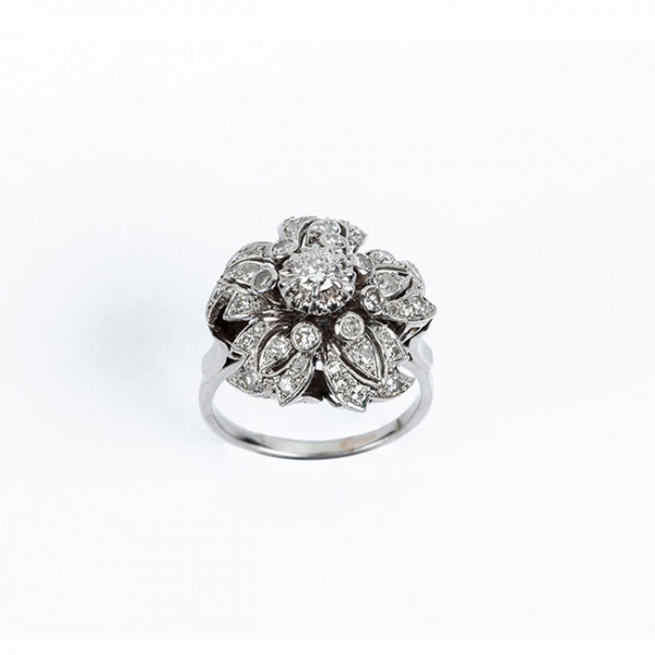 Sortija antigua en sólida montura de platino. Motivo en flor-rosetón con un limpio y blanco diamante 