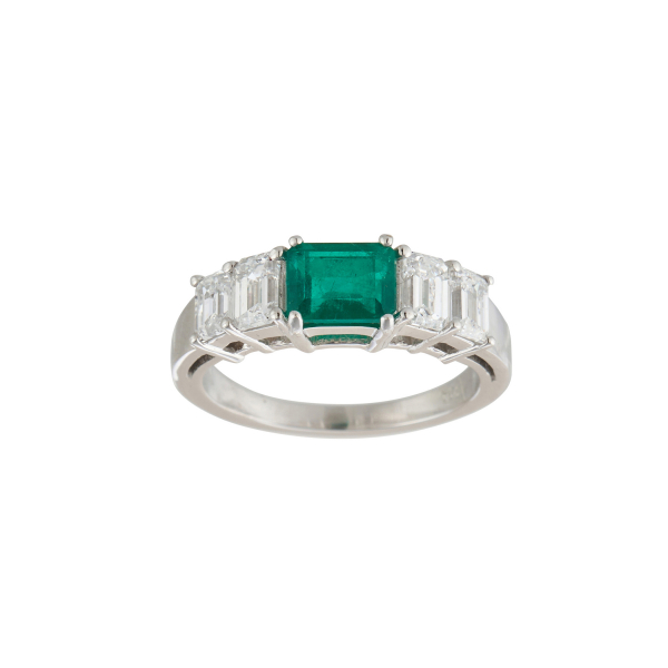 Sortija en oro blanco con esmeralda colombiana custodiada por diamantes talla esmeralda engastados en garras.