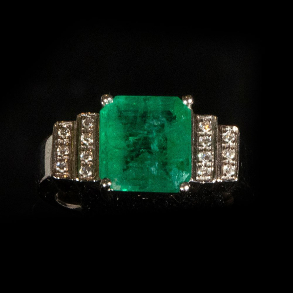 Sortija Art Decó en oro blanco de 18 k con esmeralda natural de Brasil y diamantes talla brillante.