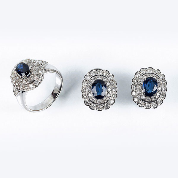 Conjunto de sortija y pendientes en s&oacute;lida montura de oro blanco 18 K, con centro de bello zafiro fino azul