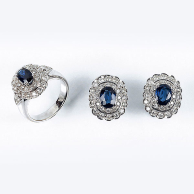 Conjunto de sortija y pendientes en s&oacute;lida montura de oro blanco 18 K, con centro de bello zafiro fino azul