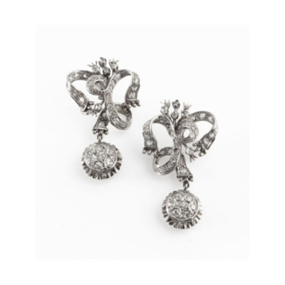Pendientes largos en oro blanco en forma de lazo cuajado de diamantes y colgante con orla de 7 diamantes talla brillante cada uno con un peso total de 0,50 cts. aprox.
