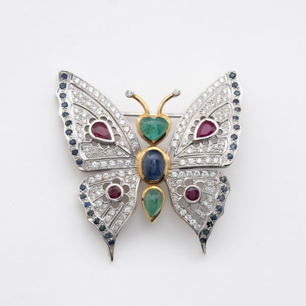 Broche dise&ntilde;o mariposa en oro bicolor, cuerpo con cabujones de esmeralda y zafiro azul tallas oval y coraz&oacute;n 