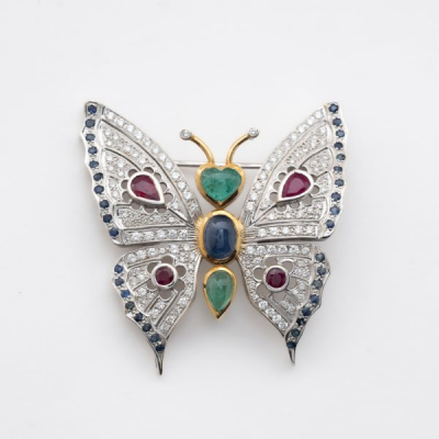 Broche dise&ntilde;o mariposa en oro bicolor, cuerpo con cabujones de esmeralda y zafiro azul tallas oval y coraz&oacute;n 