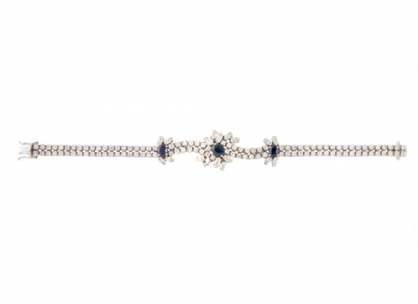 Brazalete de brillantes y zafiros, con dise&ntilde;o de tres flores como centros de doble rivi&egrave;re de brillantes.   