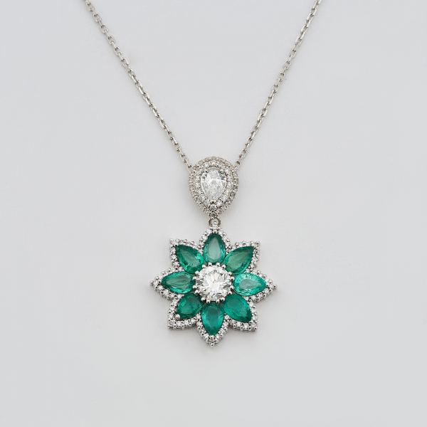 Gargantilla en oro blanco con làgrima y flor de esmeraldas de Brasil talla perilla y diamantes talla brillante. 