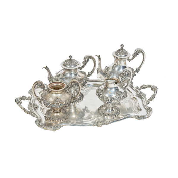 Juego de café de cinco piezas en plata portuguesa punzonada con decoraciones repujadas de roleos, acantos, volutas, veneras y motivos vegetales cincelados en el asiento, s.XX. 