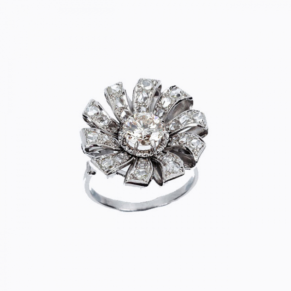 Bella sortija vintage en forma de flor, en platino, con un limpio y blanco diamante natural central, talla brillante 