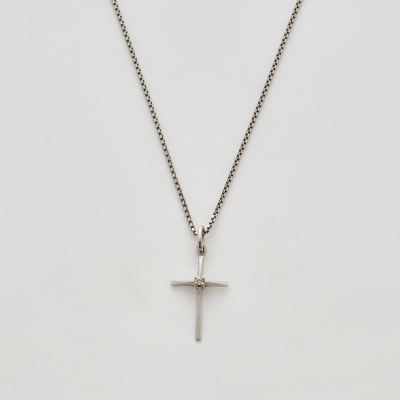Colgante dise&ntilde;o cruz en oro blanco mate y brillo con un diamante talla brillante engastado en garras, 3 x 1,5 cm