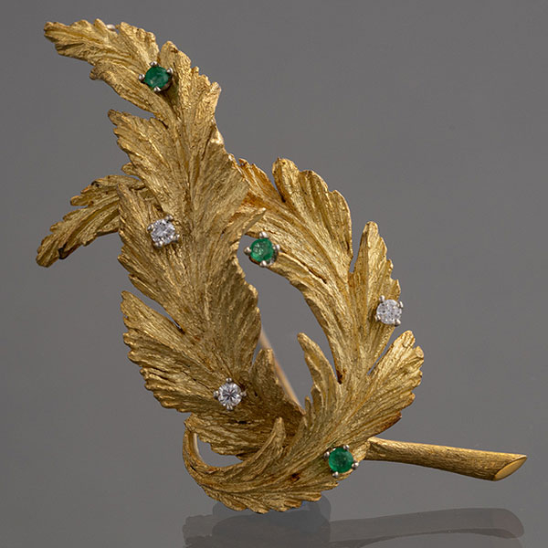 Broche en forma de hoja en oro amarillo de 18kt con brillantes y esmeraldas.
