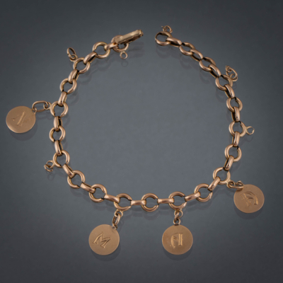 Cadena de eslabones en oro amarillo de 18 kt con cuatro medallas con letras grabadas.