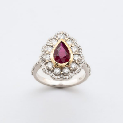 Sortija roset&oacute;n en oro bicolor con rub&iacute; talla perilla y dos orlas y brazos de diamantes talla brillante.