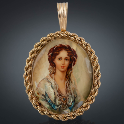 Bonito camafeo pintado sobre n&aacute;car con orla sogueada en oro amarillo de 18 kt.