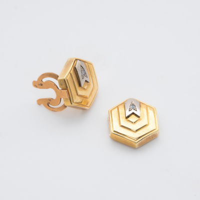 Tapa botones dise&ntilde;o exagonal en oro bicolor con diamante talla brillante engastado en gran&eacute;.
