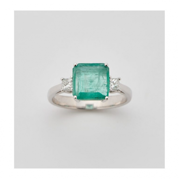 Sortija en oro blanco con esmeralda talla octogonal custodiada por diamantes talla princesa.