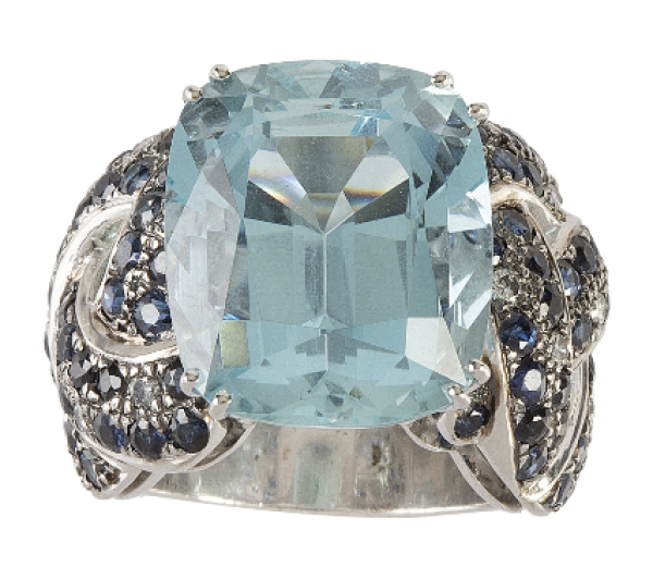 Sortija con gran aguamarina central de intenso color en talla cojín, con montura de bandas trenzadas de zafiros adornadas con brillantes. 