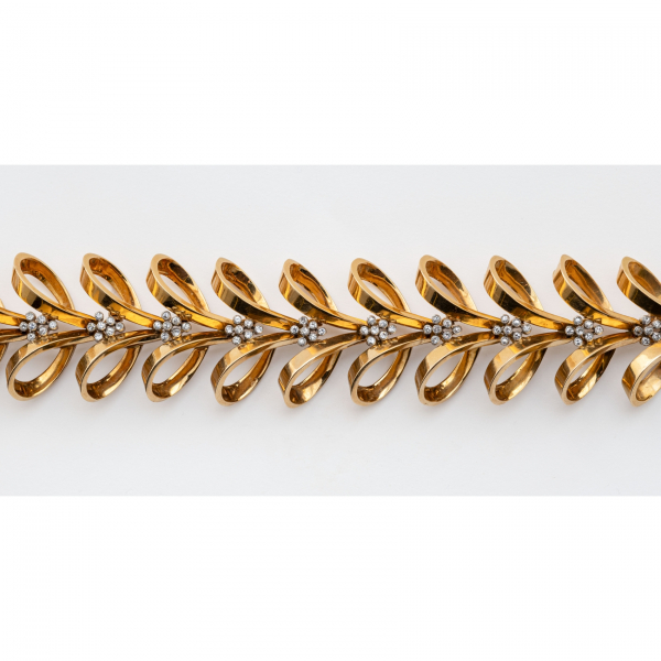 Brazalete en oro bicolor con lazadas y conjuntos de diamantes talla 8/8 engastados en chatón. 