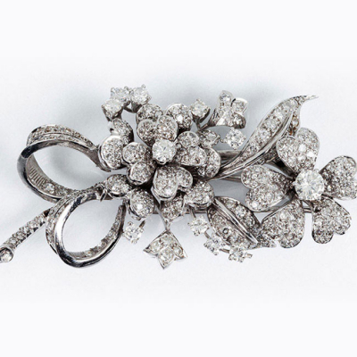 Elegante alfiler vintage en sólida montura de platino (u oro blanco 18 K), con motivo de flores y lazos