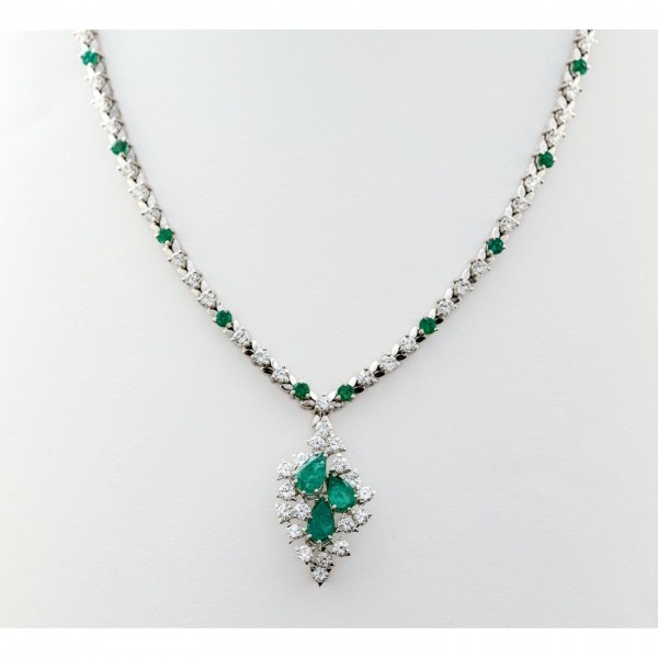 Gargantilla en oro blanco con cadena diseño rivière y colgante en cascada de diamantes talla brillante y esmeraldas tallas redonda y perilla engastados en garras. 