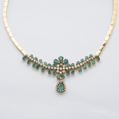 Gargantilla de eslabones planos articulados en oro con un centro de esmeraldas talla perilla y diamantes talla brillante engastados en garras.