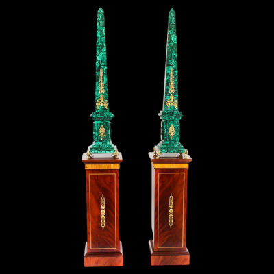 Decorativa pareja de Obeliscos relizados en Malaquita con aplicaciones en ormolu sobre peanas de caoba, siglo XX.