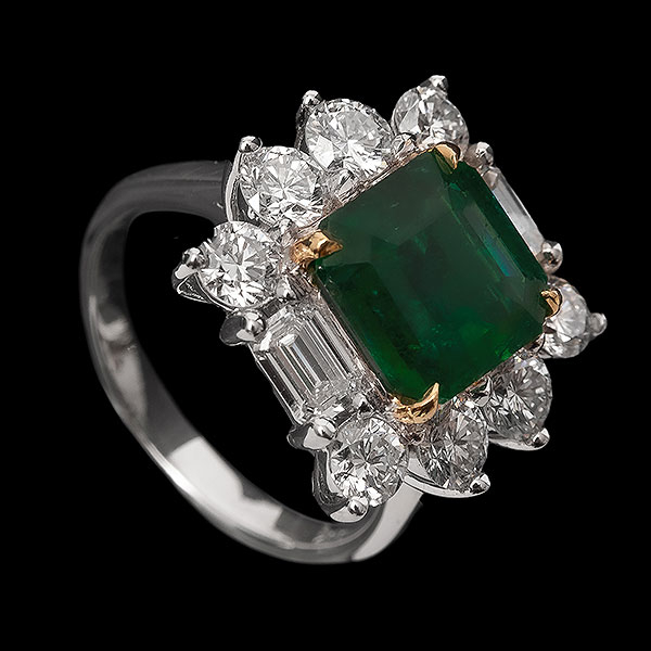 Sortija rosetón en oro bicolor con esmeralda de Zambia talla octogonal, 3,12 ct aprox. y orla de diamantes  