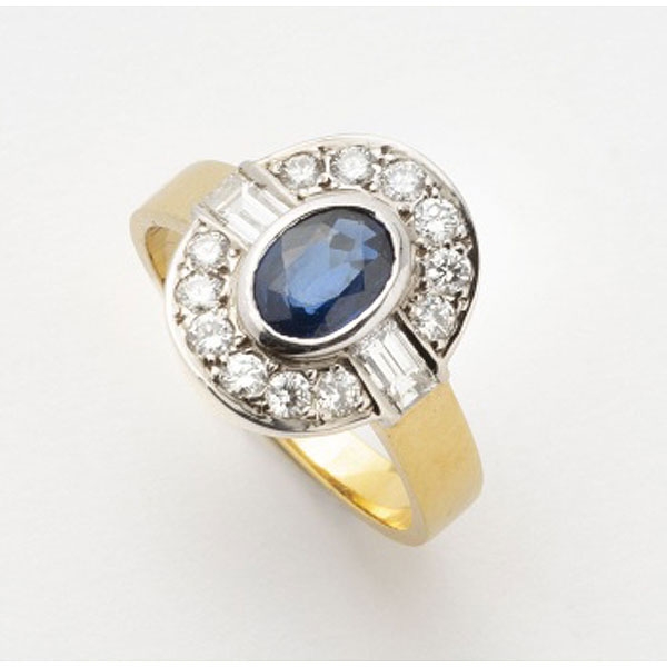 Sortija en oro amarillo con zafiro azul central y orla de diamantes talla brillante y 2 diamantes talla baguette