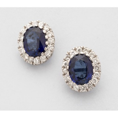 Pendientes en oro blanco con 2 zafiros azules orlados de diamantes talla brillante.