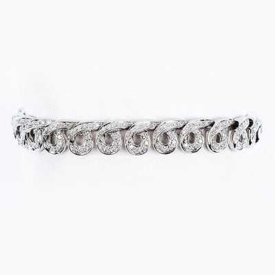 Elegante brazalete firmado por DAMIANI, en sólida montura de oro blanco que forma motivos espirales cuajados en filas de limpios y blancos diamantes talla brillante