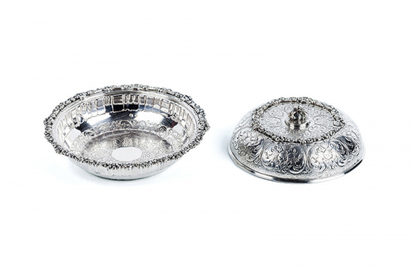 Pequeño centro vintage con tapa, en plata de ley contrastada (estrella de 5 puntas), con profusa decoración vegetal y roleos, en el cuerpo y en el borde, en relieve.