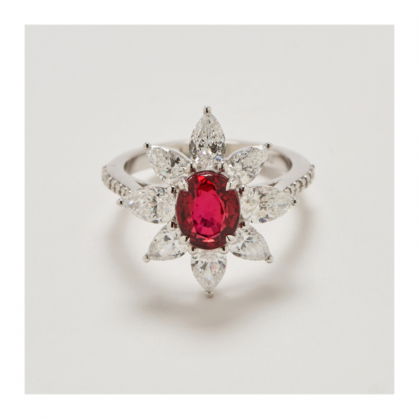 Sortija rosetón en oro blanco con rubí de Tanzania talla oval orlado por diamantes talla perilla.