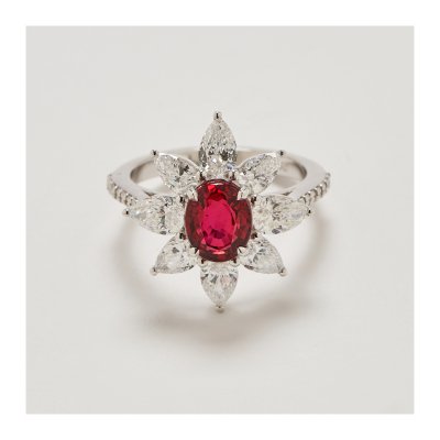 Sortija rosetón en oro blanco con rubí de Tanzania talla oval orlado por diamantes talla perilla.