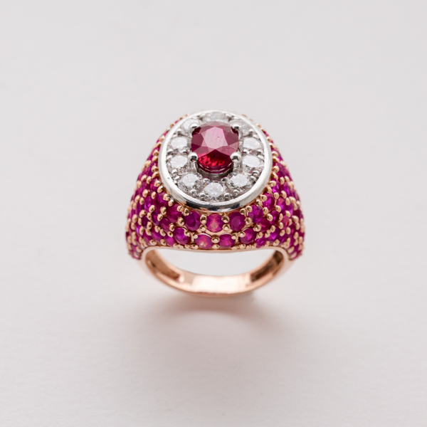 Sortija sello en oro rosa y blanco cuajado de rub&iacute;es talla redonda y roset&oacute;n central con rub&iacute; talla oval orlado por diamantes talla brillante.