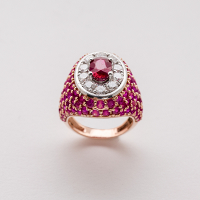 Sortija sello en oro rosa y blanco cuajado de rub&iacute;es talla redonda y roset&oacute;n central con rub&iacute; talla oval orlado por diamantes talla brillante.