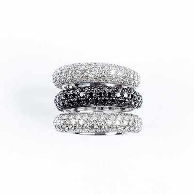 Conjunto de alta joyería formado por tres anillos en sólida montura de oro blanco, con frente en pavé de diamantes, talla brillante, blancos en dos de ellos y negros en el otro. 180 bts blancos: 3.00 ct aprox