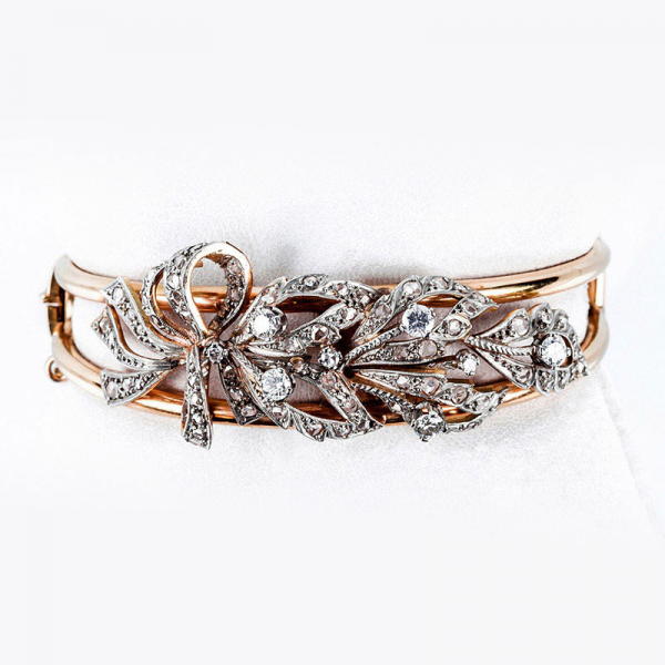 Brazalete esclavo vintage en &#039;esqueleto&#039; de oro amarillo 18 K, con lazada vegetal decorado con limpios y blancos diamantes 